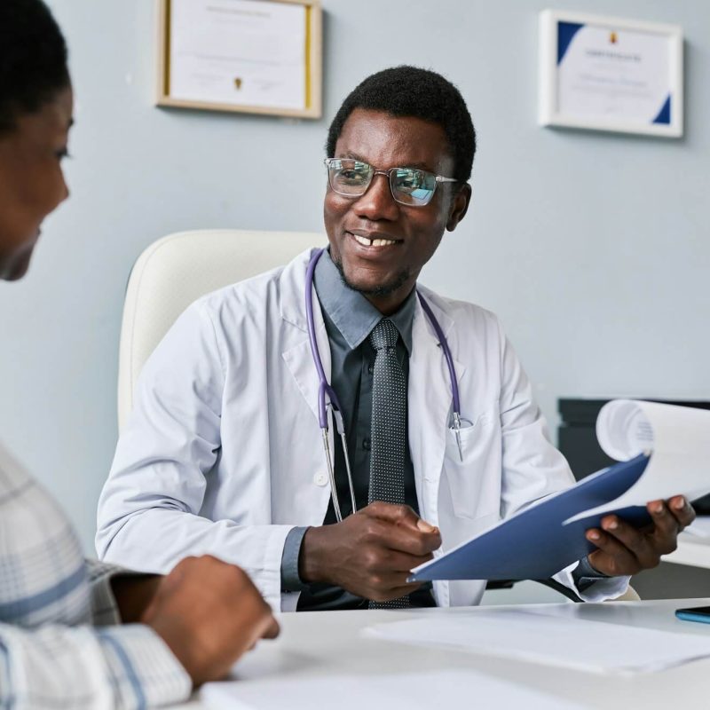 smiling-black-doctor-consulting-female-doctor-in-clinic.jpg